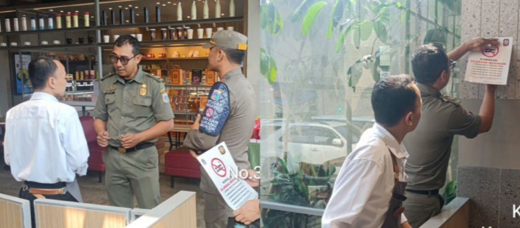 Petugas Satpol PP meninjau ketersediaan stiker larangan merokok di sebuah restoran. (X@Satpolpp_Jakbar)